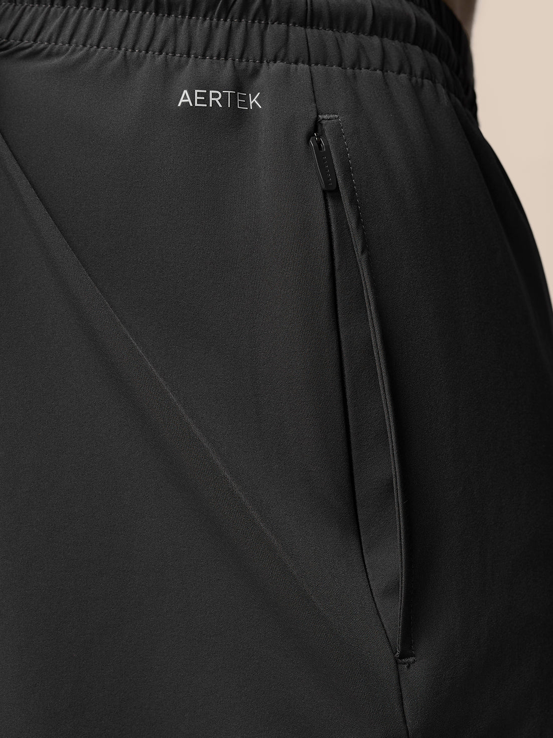 Close-up of black Adapt Training 7 inch shorts showing AerTek branding and a side zip pocket.