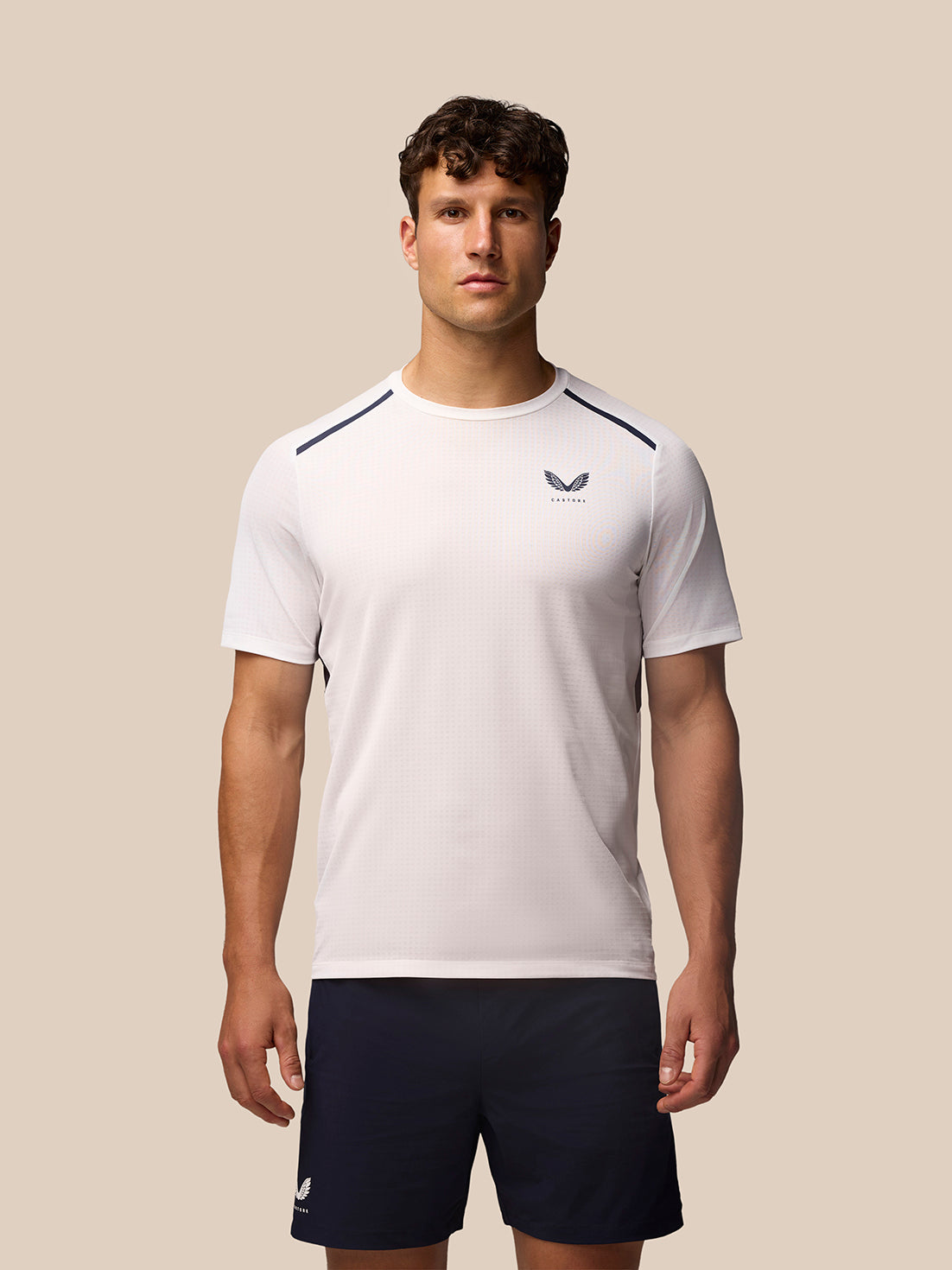Model wearing white Apex Training T-Shirt with navy shoulder piping and Castore branding.
