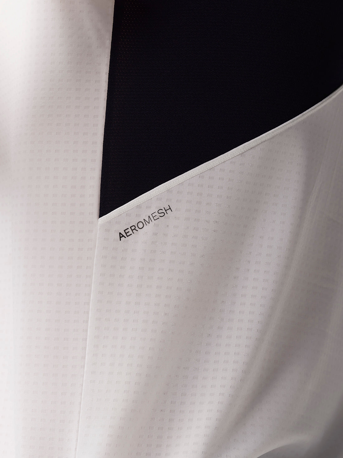 Close-up of white Apex Training T Shirt fabric showing Aeromesh paneling and textured weave.