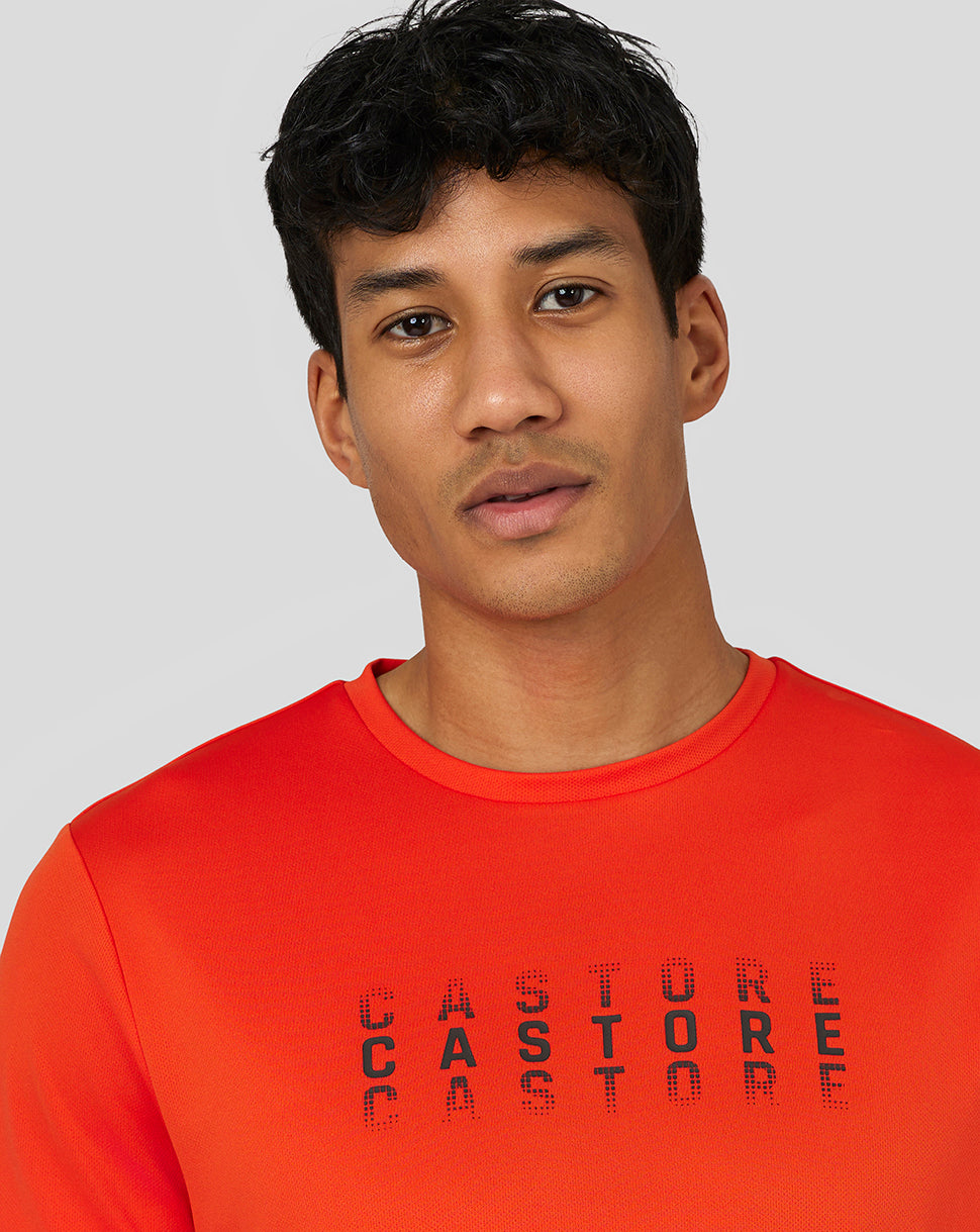 Close up of chest showing Castore graphic across the bright orange Flow Short Sleeve Graphic T Shirt.
