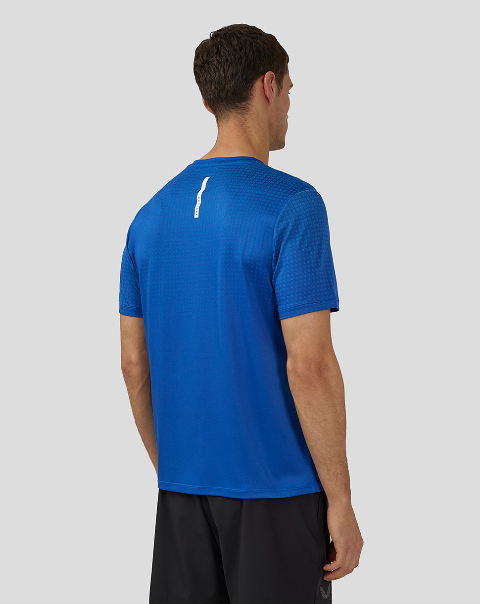 Back view of royal blue Flow Short Sleeve Knit T-Shirt with a white vertical logo detail on the upper back.