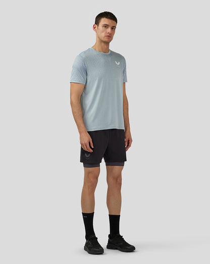 Male model wearing Stone Blue Flow Short Sleeve Knit T Shirt with dotted knit pattern and Castore logo on the chest
