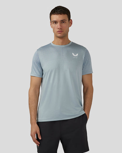Male model front view wearing Stone Blue Flow Short Sleeve Knit T Shirt with dotted upper panel and Castore logo on chest