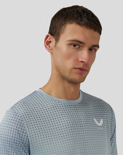 Close up of male model wearing Stone Blue Flow Short Sleeve Knit T Shirt showing dotted pattern on shoulder with Castore logo on chest