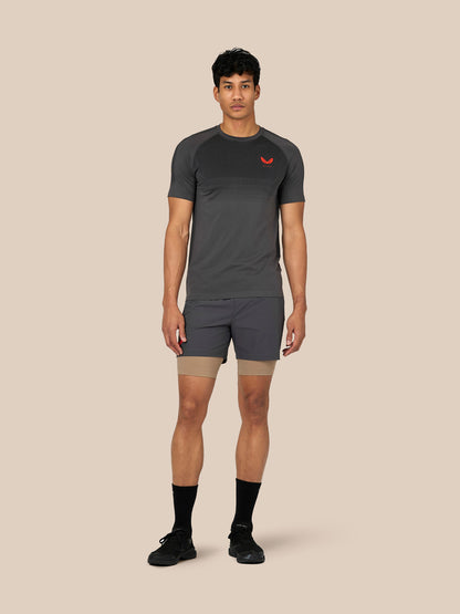 Male model wearing dark grey Flow Training T-Shirt with a dotted chest panel and raglan sleeves.