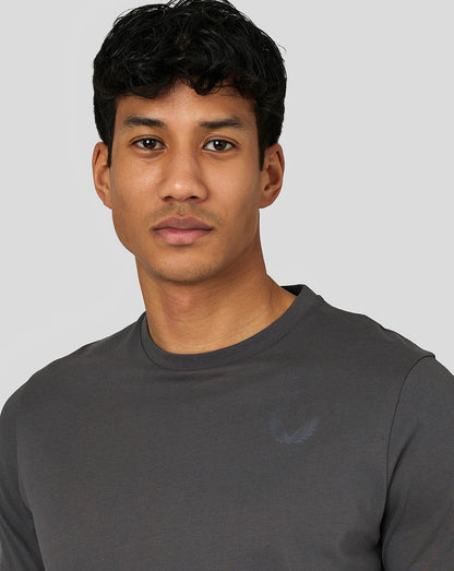Close-up of a model wearing a dark gray Crew neck T-shirt with a minimalist left chest logo.