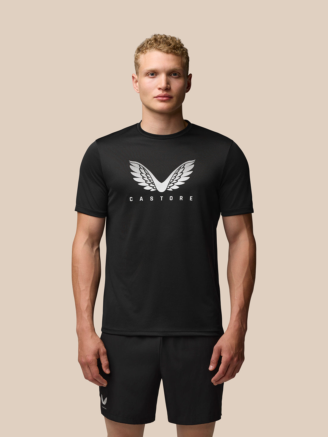 Front view of a man in a black Adapt Graphic Training T-Shirt with a white wing graphic on the chest