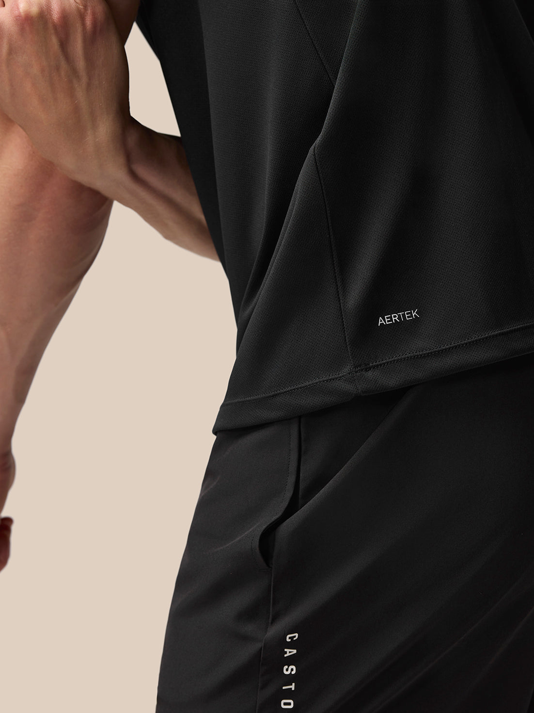 Close up of black Adapt T shirt fabric with AERTEK branding at the back hem.