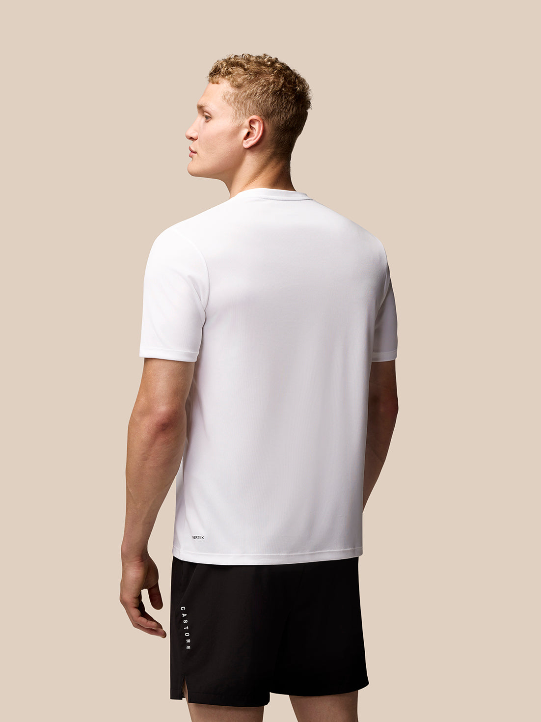 Side profile of a man wearing white Adapt Graphic Training T-Shirt with a chest Castore wings logo