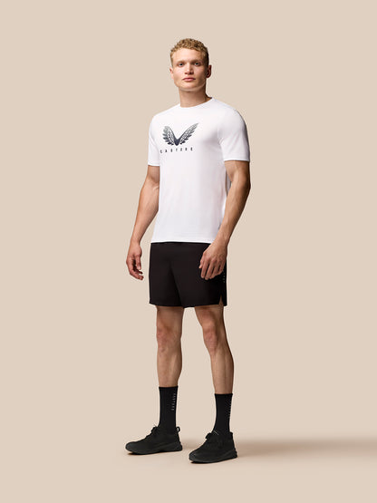 Male model wearing white Adapt Short Sleeve Graphic T Shirt with Castore wings logo and black shorts