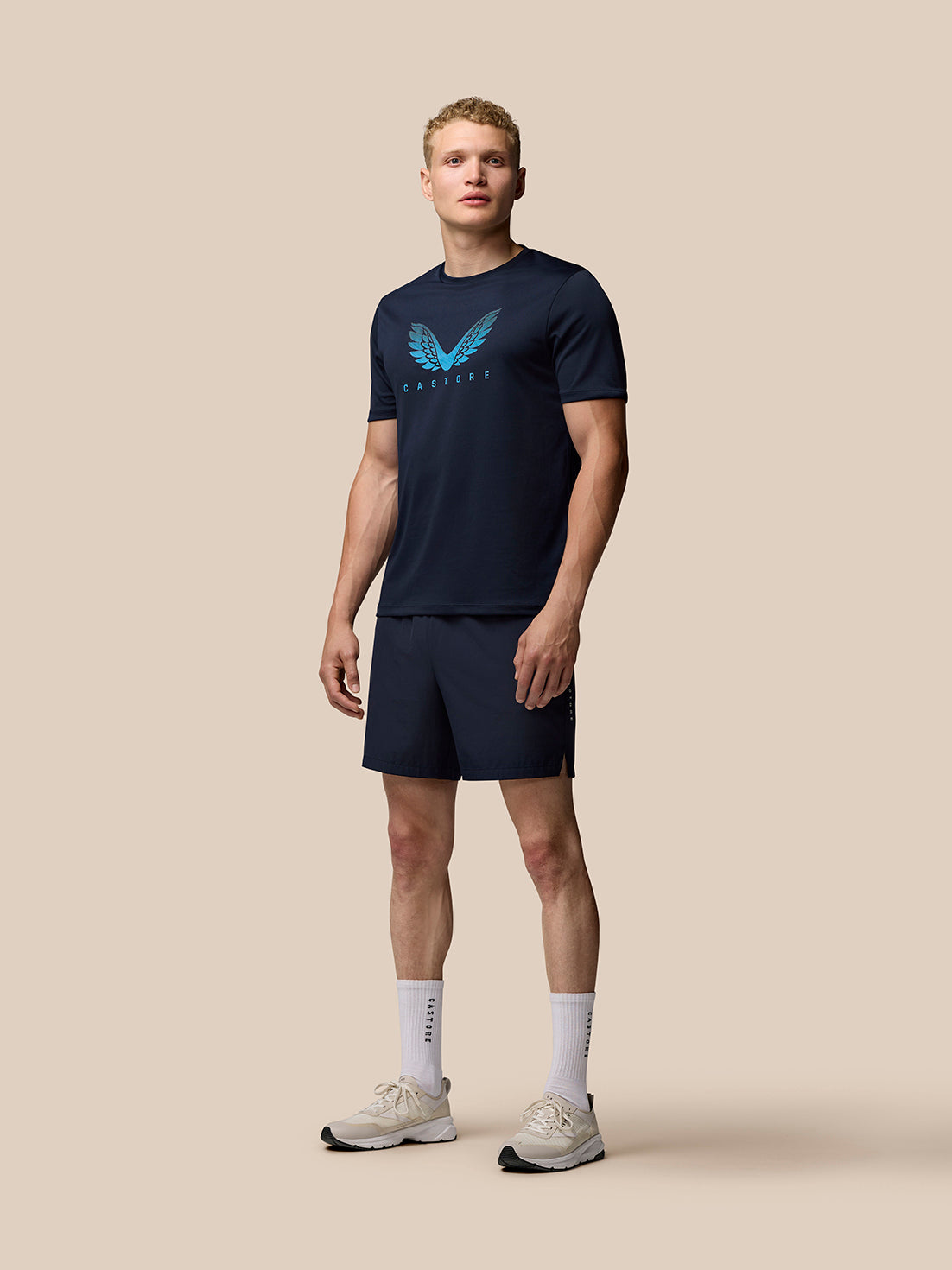 Front view of a model wearing midnight navy Adapt Training T-Shirt with Castore wings graphic on the chest