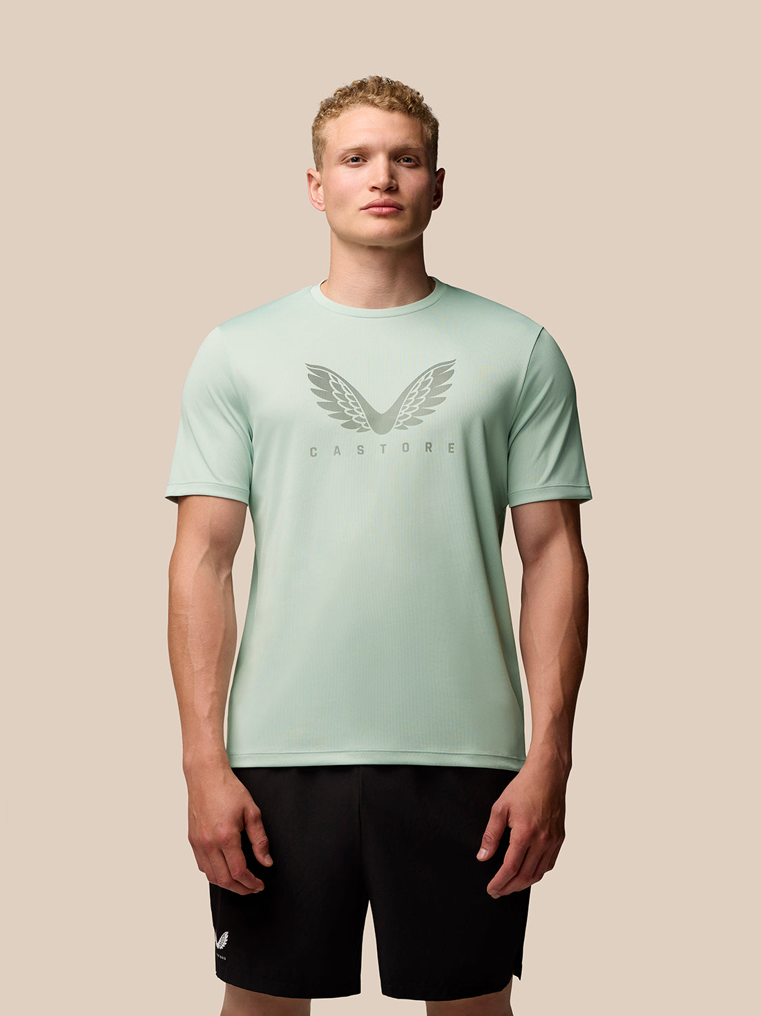 Male model wearing mint green Adapt Training T-Shirt with wing graphic on chest