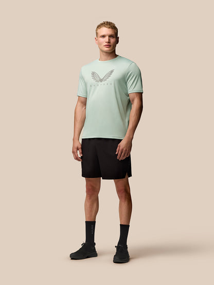 Full body view of a model wearing mint green Adapt Training T Shirt with a large Castore wings graphic on the chest