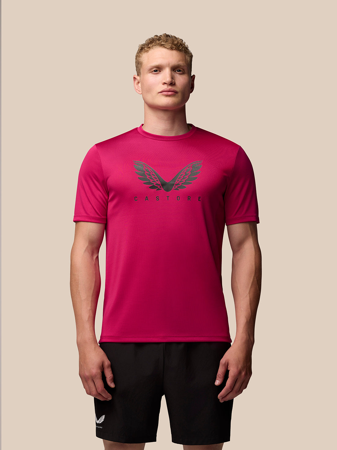 Front view of pink Adapt Training T-Shirt on a model, featuring a crew neck, short sleeves, and Castore wings graphic on the chest.