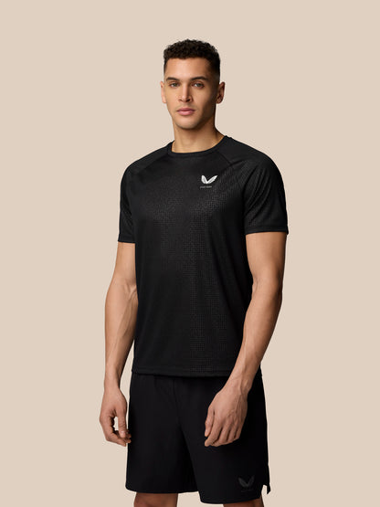 Male model wearing black Adapt Training T Shirt with all over print and Castore logo on chest.
