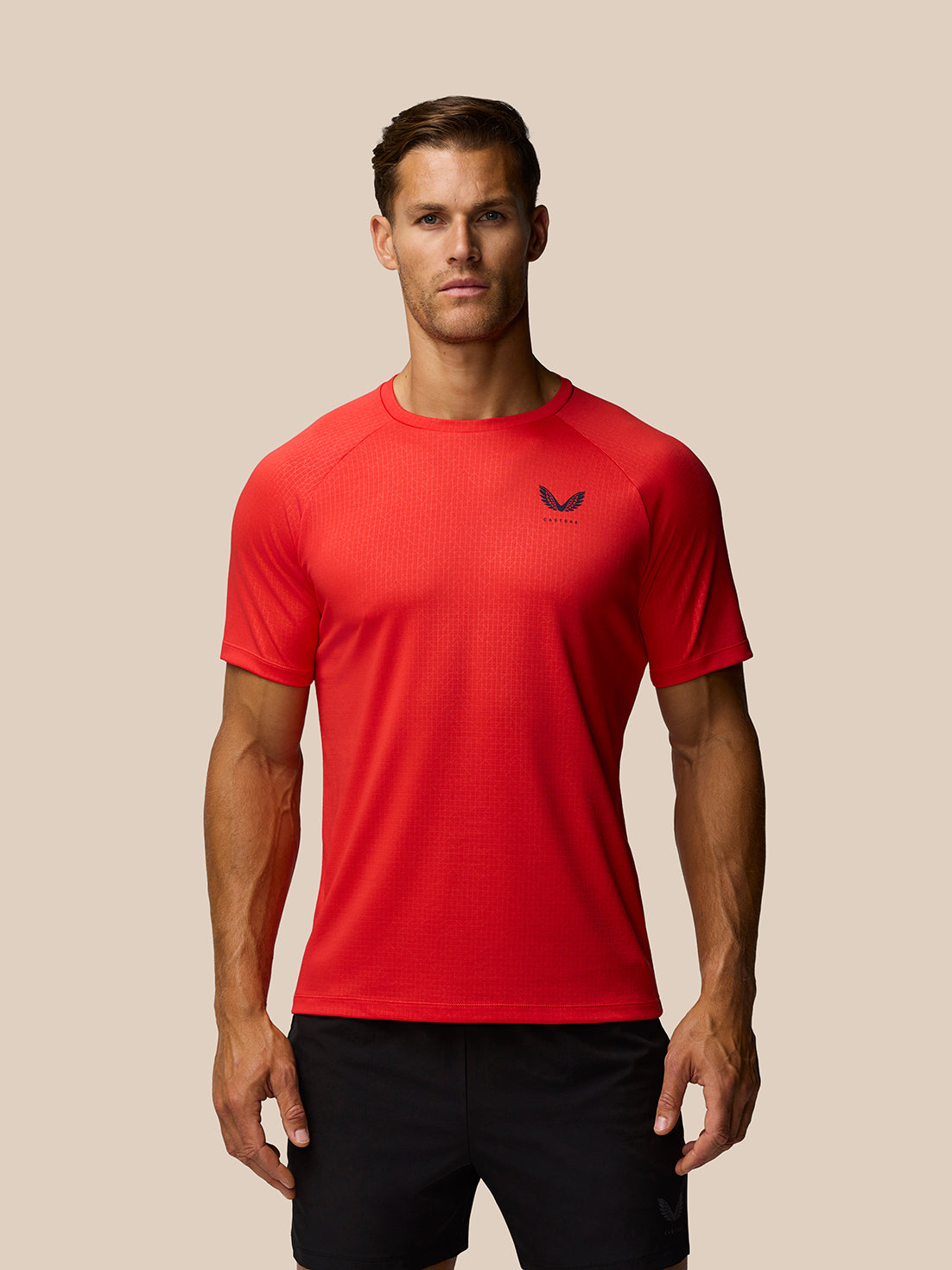 Red Adapt Training T Shirt on a male model with Castore logo on the chest and black shorts