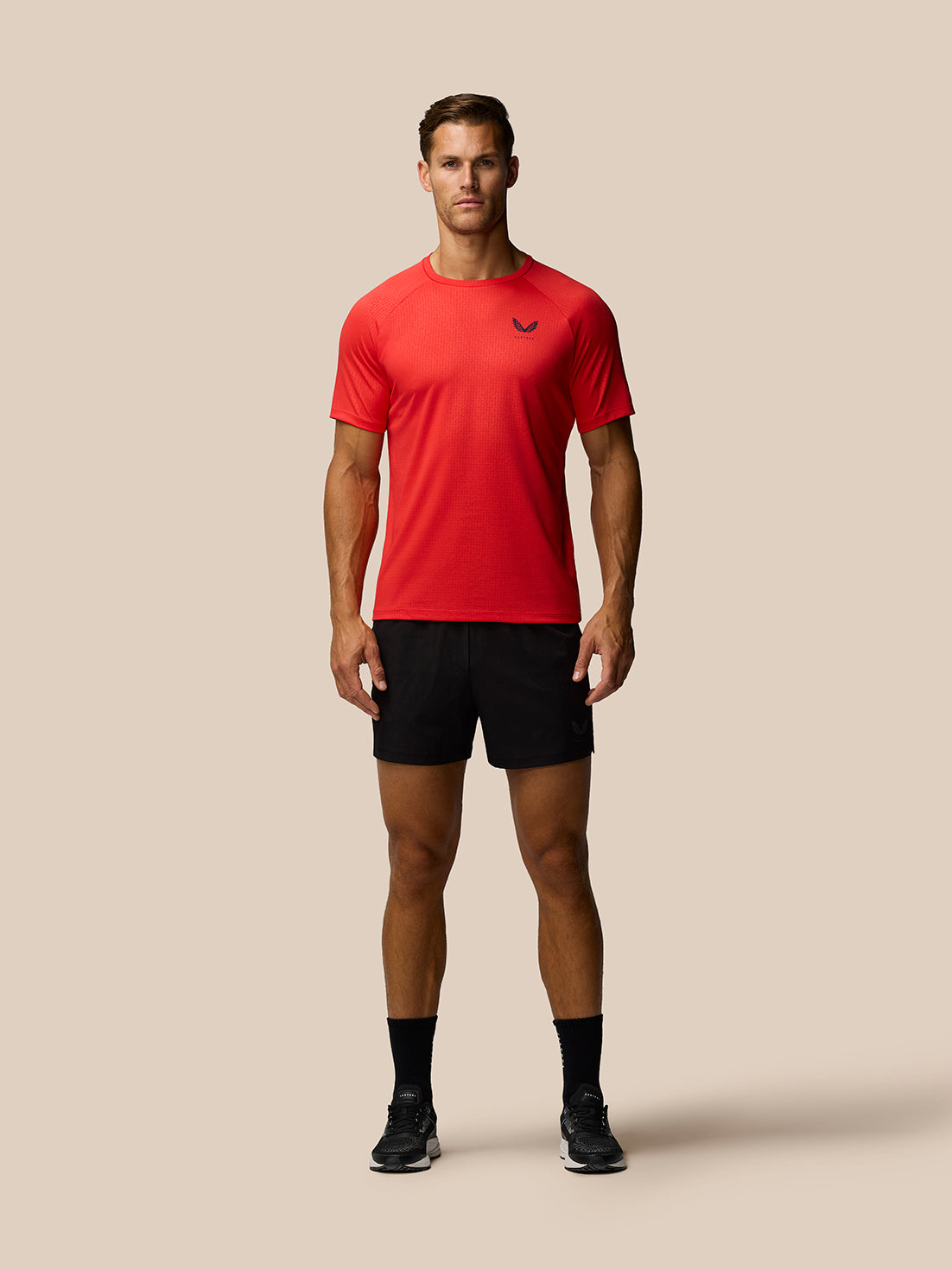 Front view of red Adapt Training T-Shirt with Castore logo on the chest and an all over print across the fabric