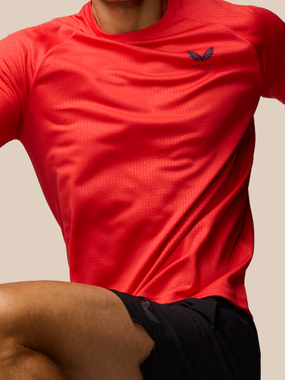 Close-up of red Adapt Training T-Shirt chest area showing Castore logo and subtle geometric print