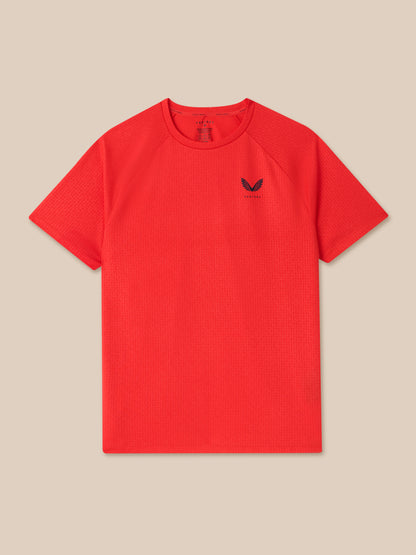 Front view of red Adapt Training T Shirt with Castore logo on the chest and an all over print.