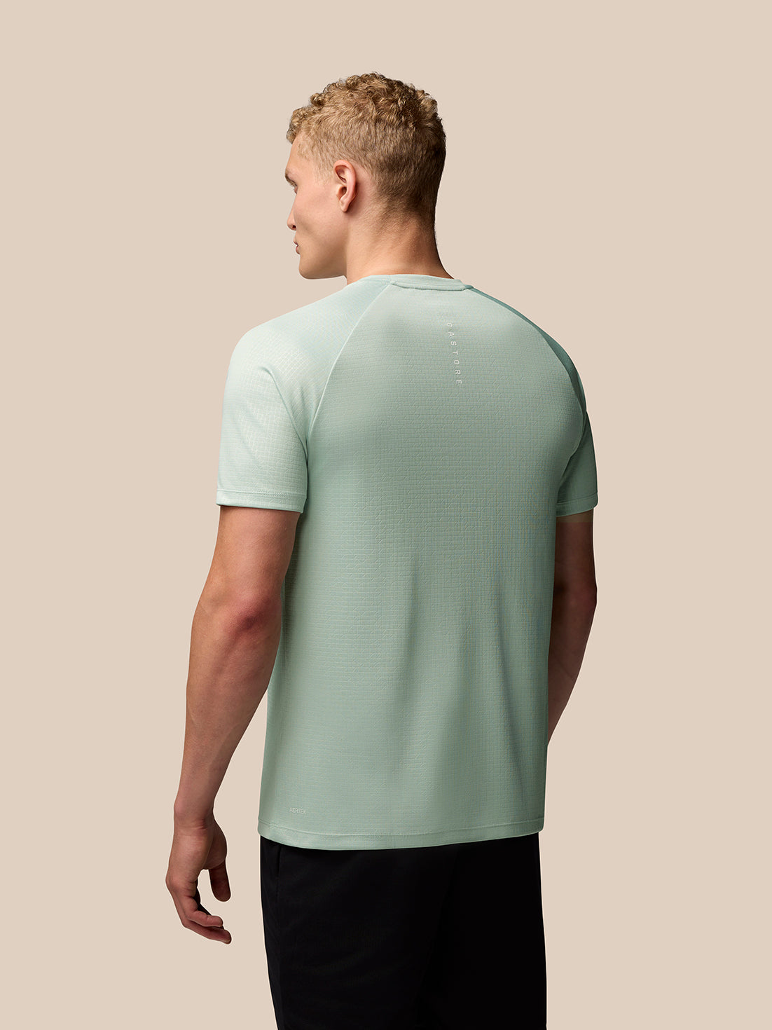 Back view of mint green Adapt Training T Shirt showing subtle vertical branding on upper back