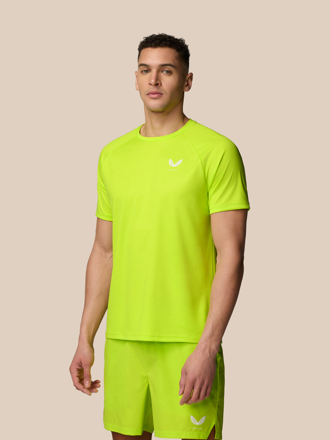 Male model wearing acid lime Adapt Training T-Shirt with crew neck raglan sleeves and Aertek sweat-wicking fabric