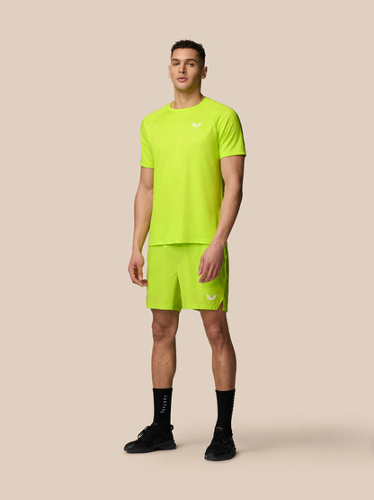 Male model wearing neon lime Adapt Training T-shirt with matching shorts in a full body shot.