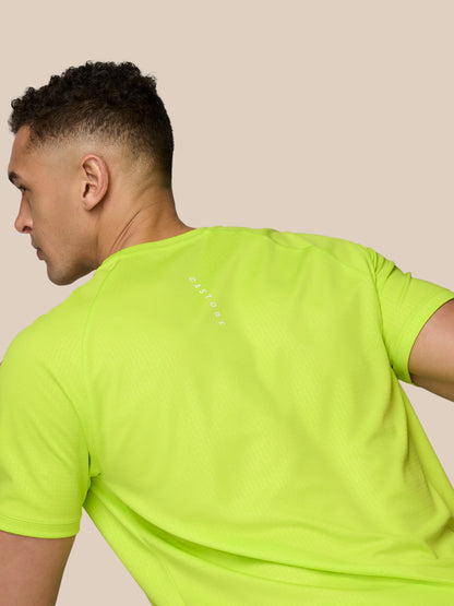 Rear view of male model in neon lime Adapt Training T-Shirt showing Castore branding along the upper back.