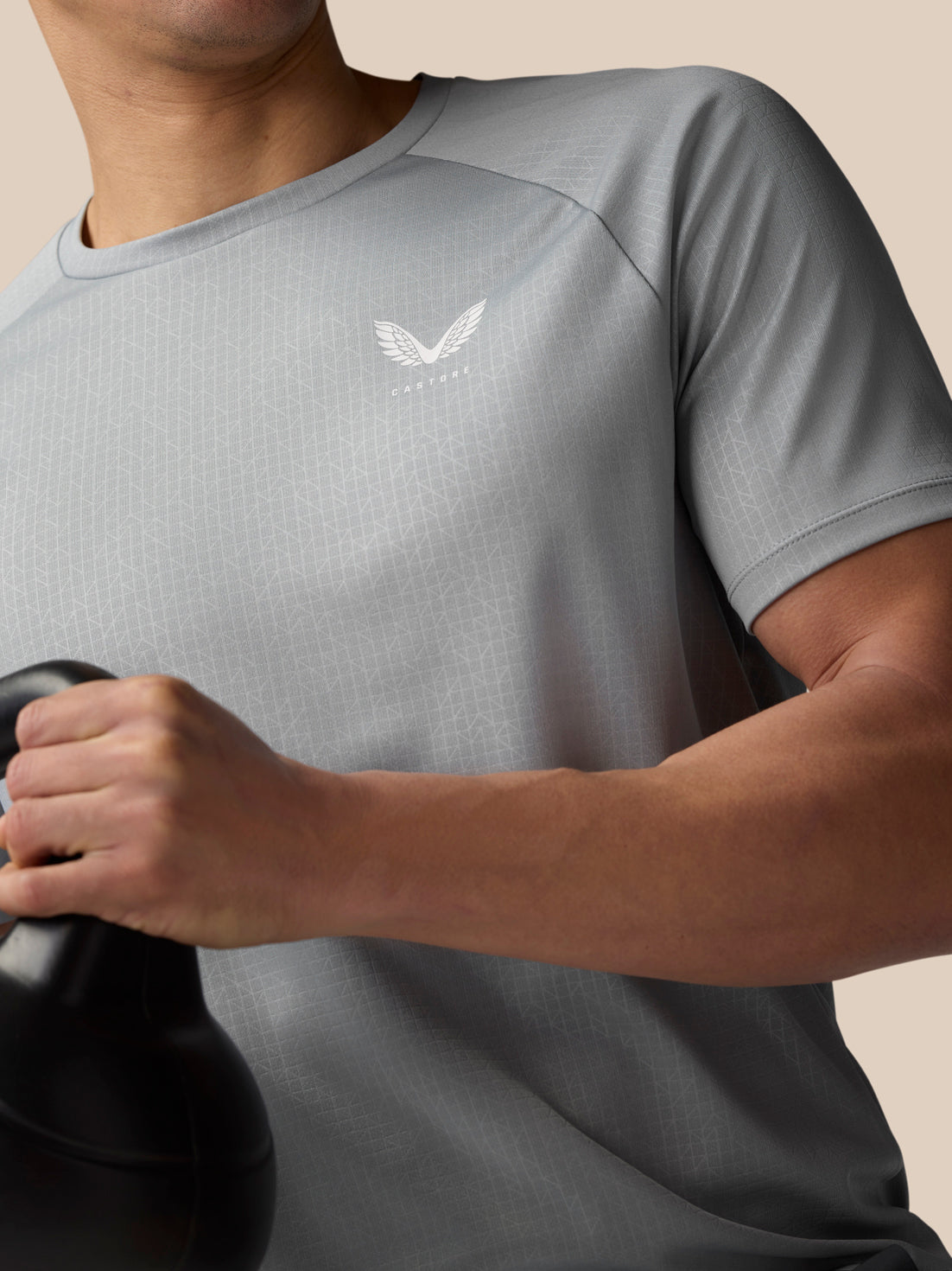 Close up of Adapt Training T Shirt in mid grey showing Castore logo on chest and subtle all over print.