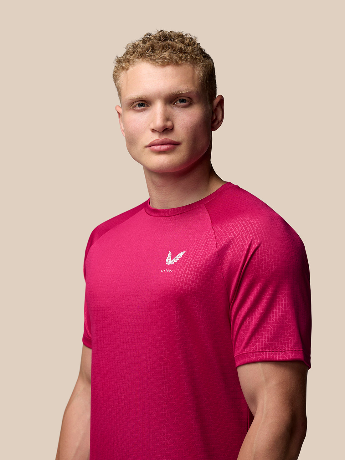 Front view of pink Adapt Training T Shirt featuring a small white Castore logo on the left chest and a geometric pattern
