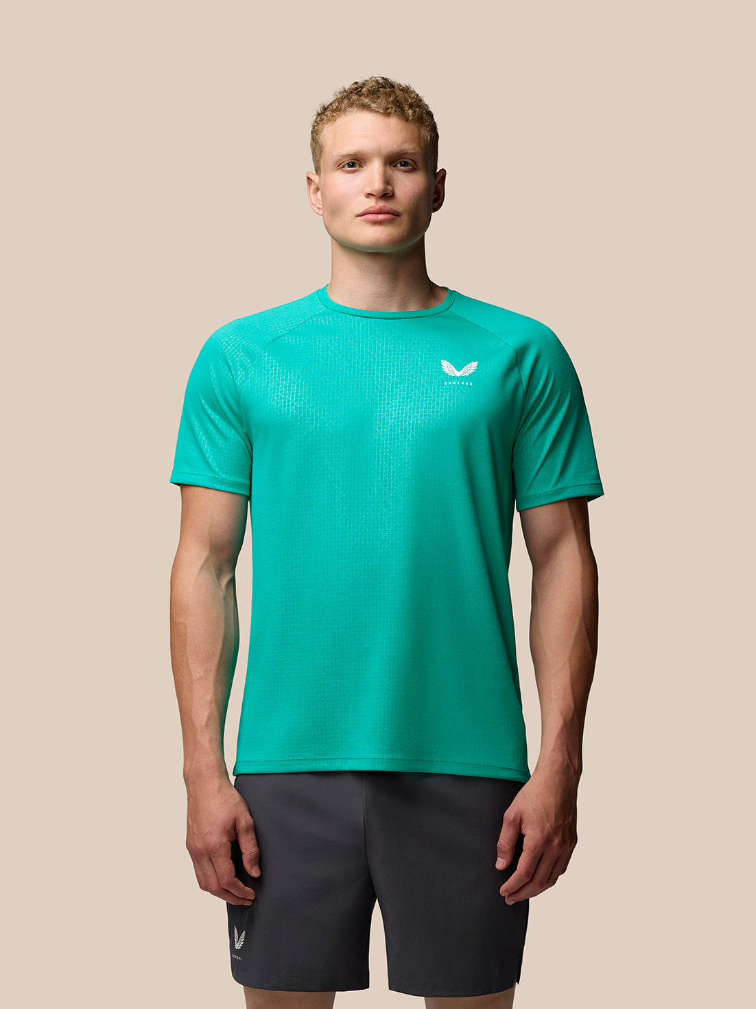 Male model wearing Adapt Training T-Shirt in bright aqua with geometric allover print and raglan sleeves