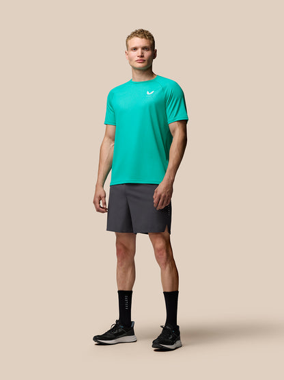 Front view of a male model in bright aqua Adapt Training T-Shirt with geometric pattern and Castore branding on the left chest