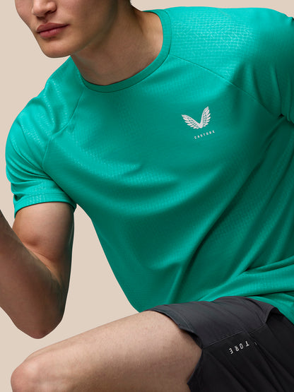 Chest area of bright aqua Adapt Training T shirt with Castore wing logo on left chest and geometric pattern