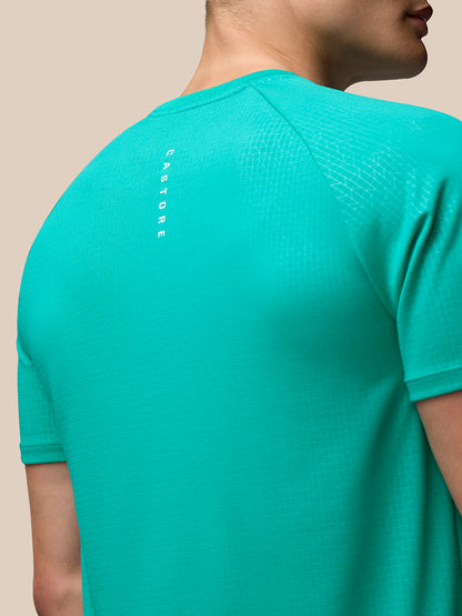 Back close up in bright aqua Adapt Training T shirt showing vertical Castore branding along the back and subtle geometric texture