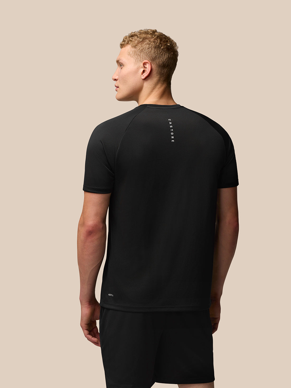 Back view of a man wearing black Adapt Training T Shirt showing Castore branding on the upper back