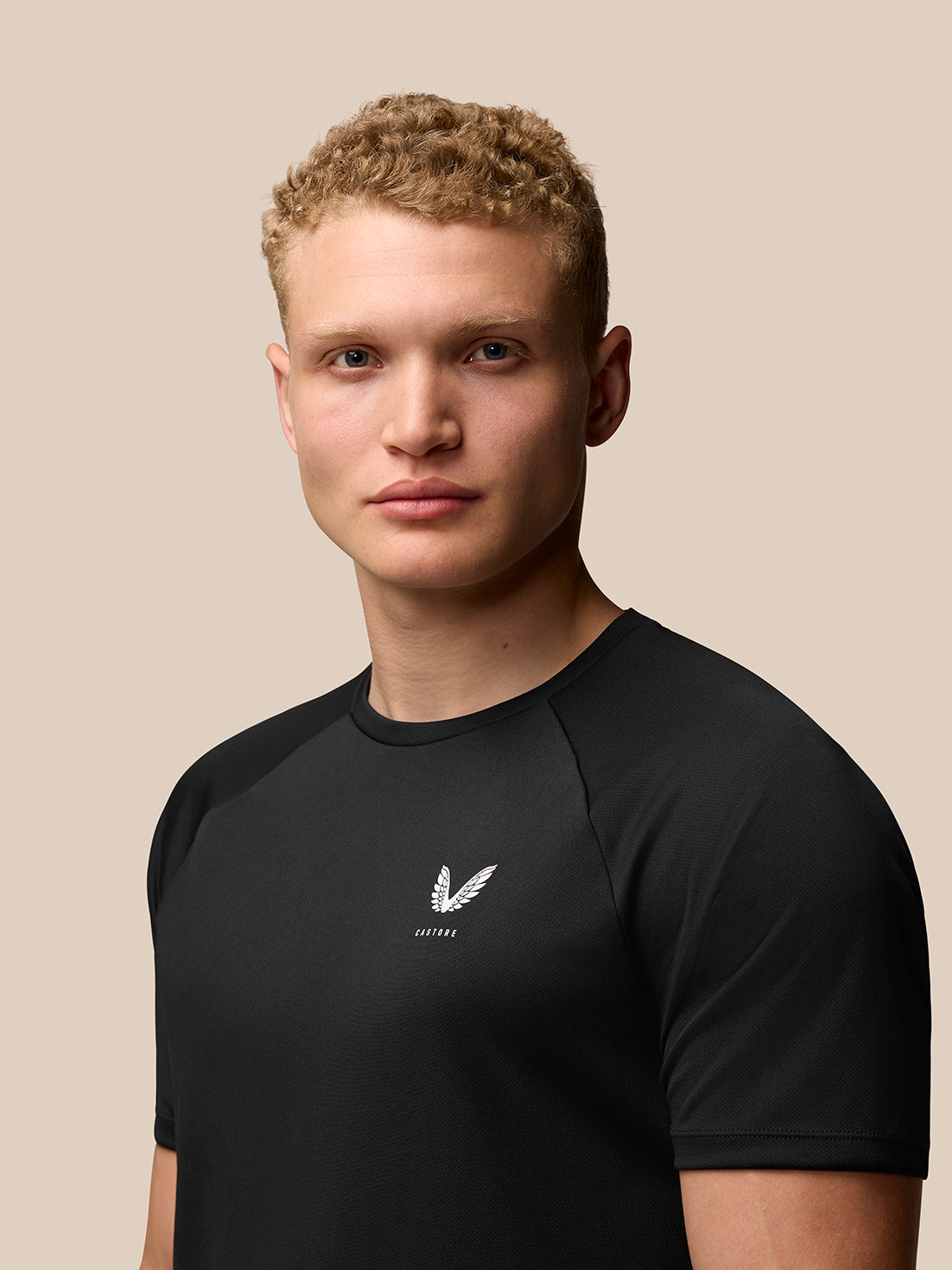 Close up of male model wearing black Adapt Training T Shirt with Castore logo on left chest
