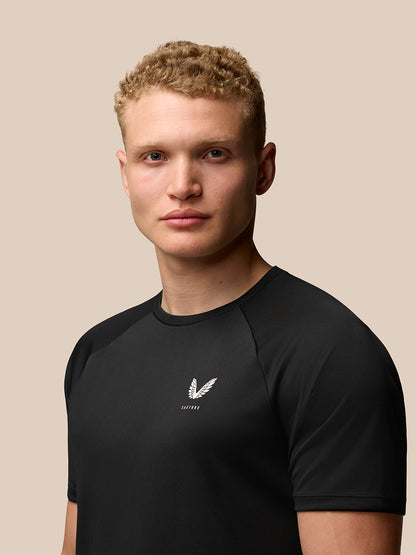 Close up of male model wearing black Adapt Training T Shirt with Castore logo on left chest