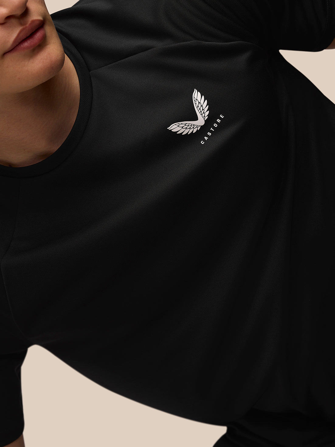 Close-up of left chest area showing the Castore wing logo on the black Adapt Training T Shirt