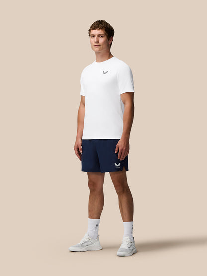 Model wearing white Adapt Training T-Shirt with Castore logo on chest and navy shorts.