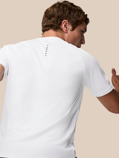 Back view of a person in a white Adapt Training T-Shirt with vertical Castore branding on the upper back.