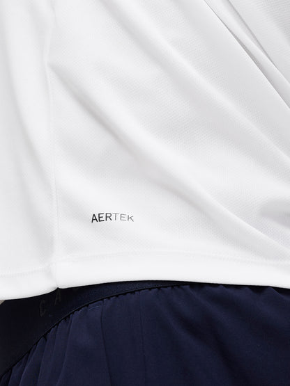 Close up of white Adapt Training T Shirt fabric with AERTEK branding near the hem, navy shorts visible in the background