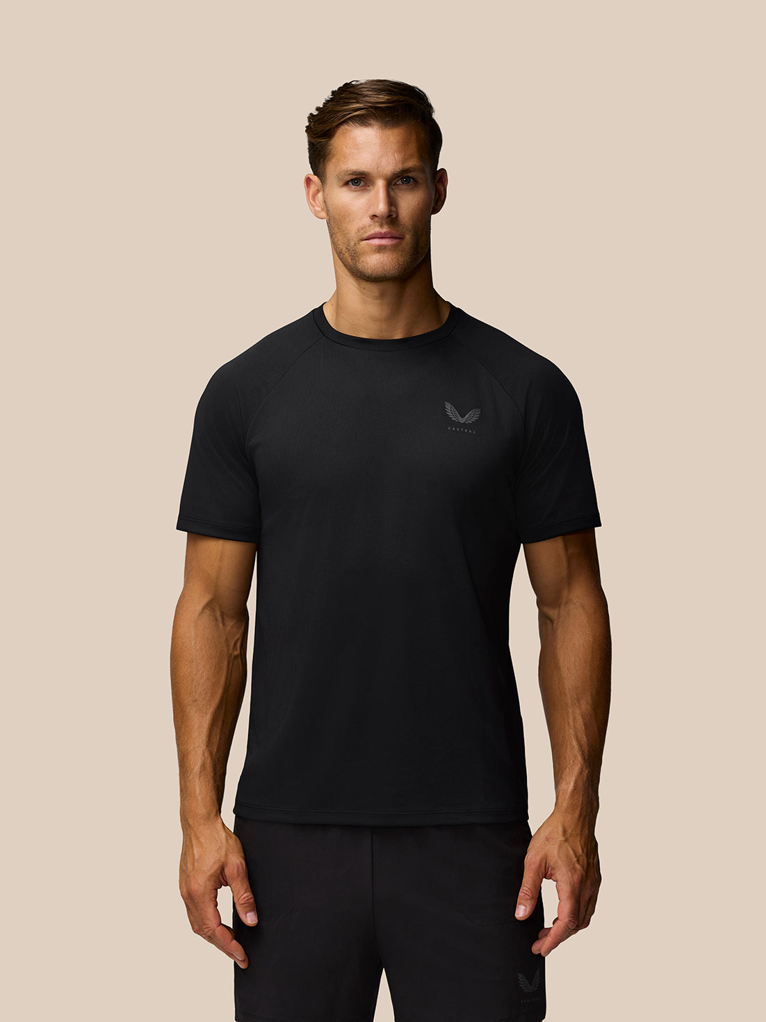 Male model wearing black Adapt Training T Shirt with crew neck and Castore logo on left chest.