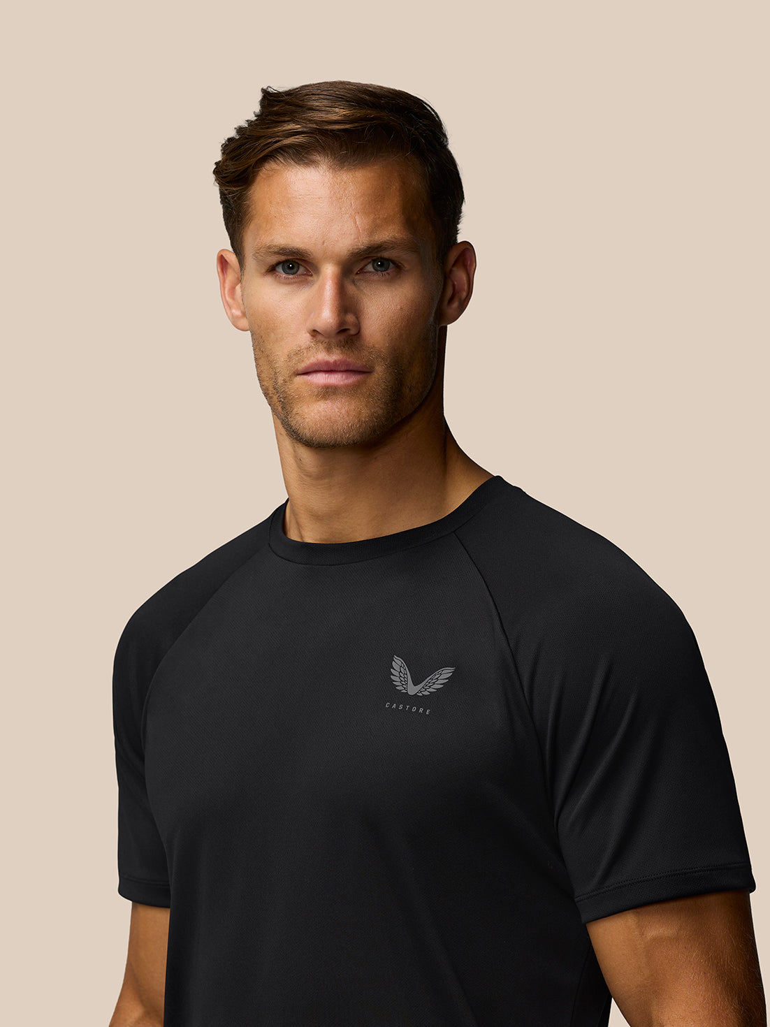Close up of a black Adapt Training T Shirt on a male model showing a subtle Castore logo on the left chest.