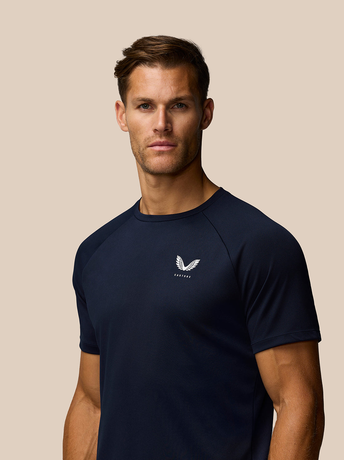 Male model wearing midnight navy Adapt Training T-Shirt with white Castore logo on the chest.