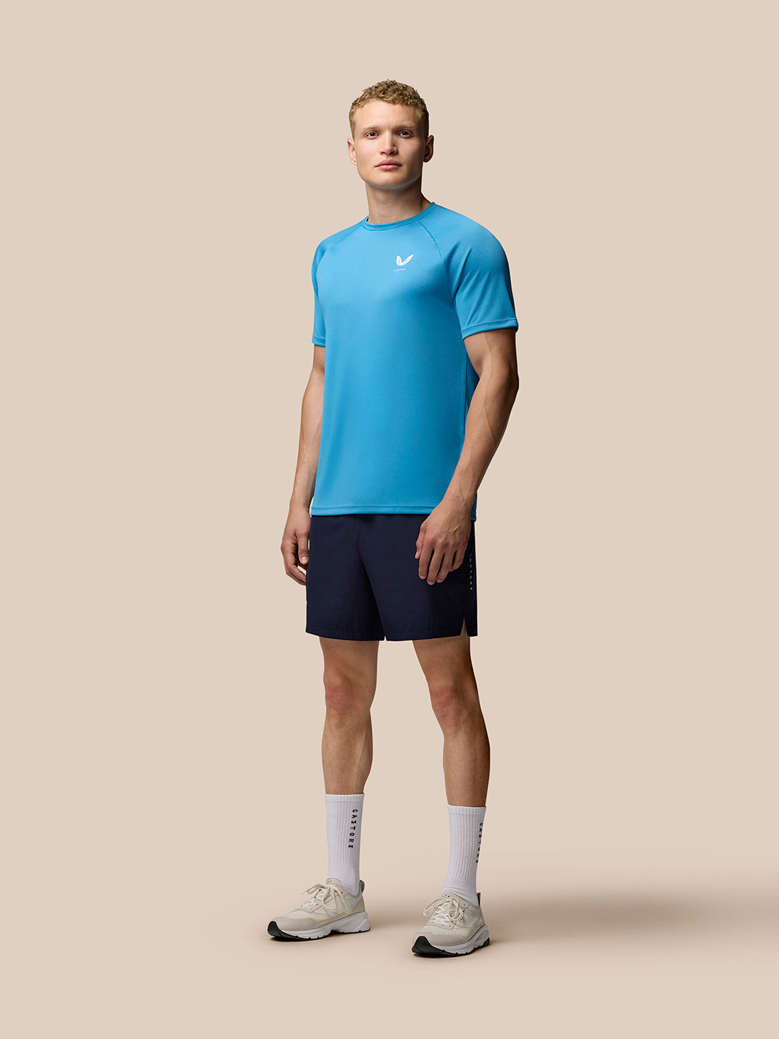 Male model wearing corn blue Adapt Training T Shirt with white Castore logo on chest and short sleeves