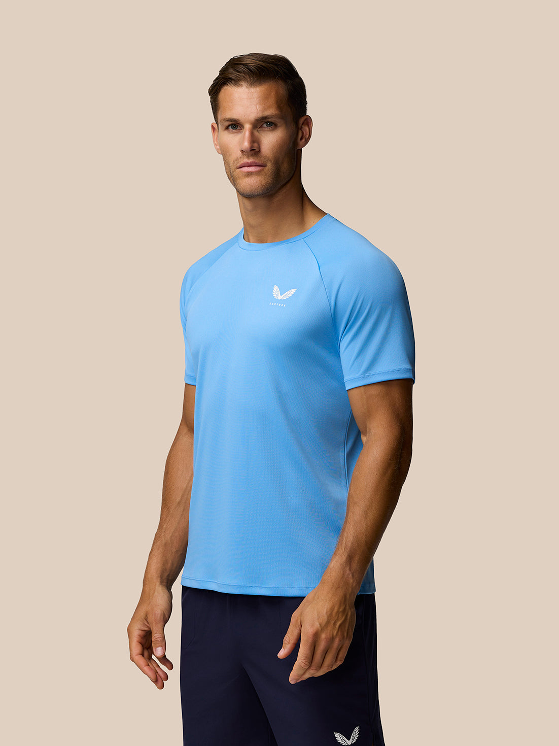 Light blue Adapt Training T-Shirt on male model front view with AerTek sweat-wicking fabric and Castore logo on left chest.