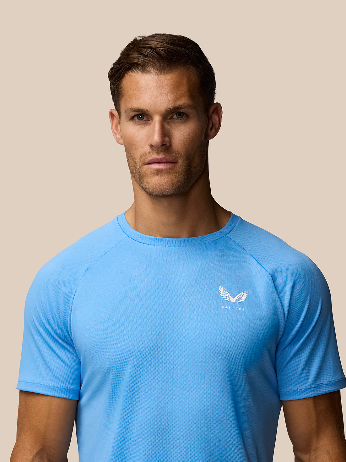 Close-up of male model wearing light blue Adapt Training T-Shirt with Castore logo on the left chest.