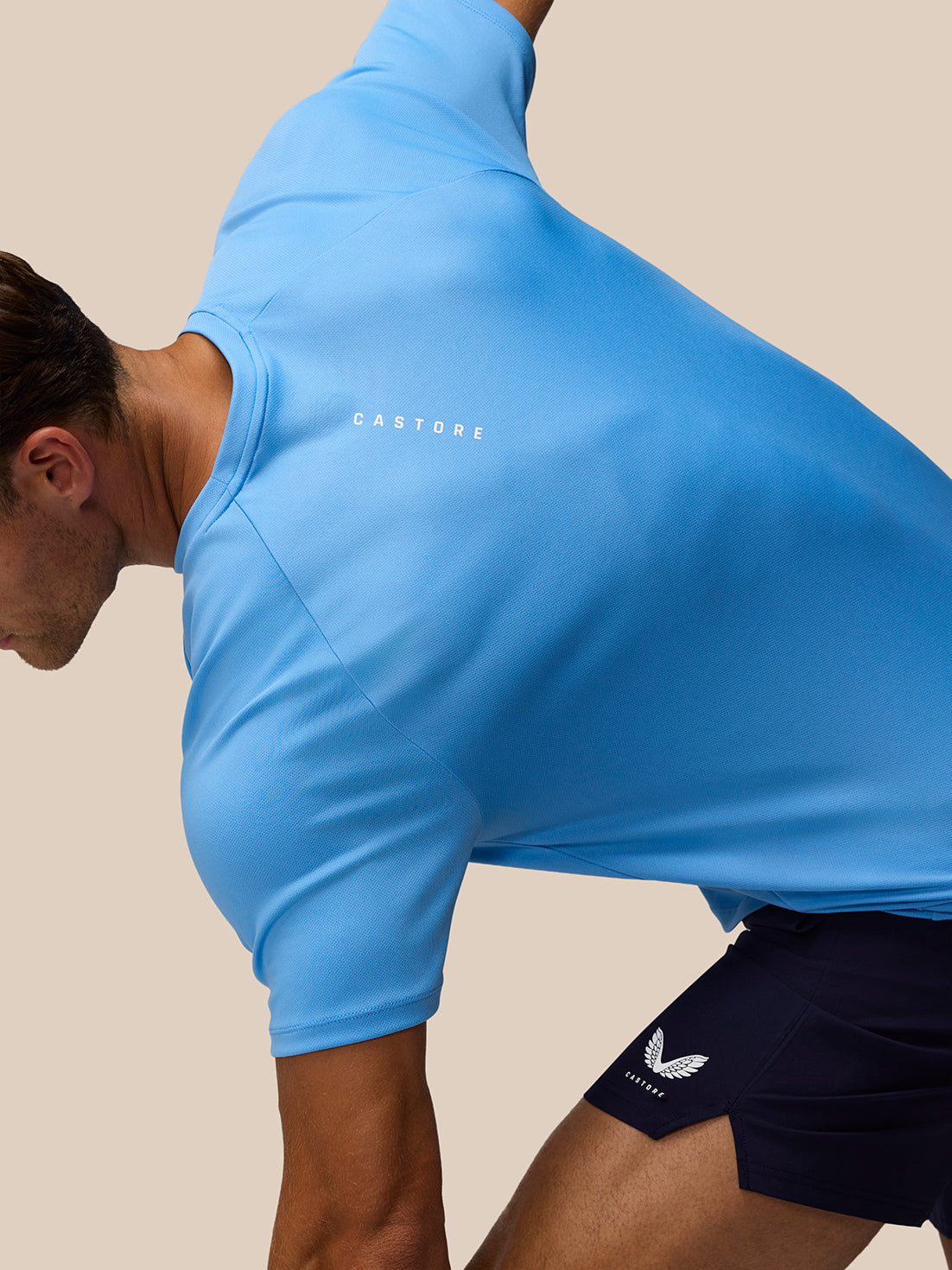 Side view of athlete in light blue Adapt Training T Shirt showcasing fabric drape and Castore logo on the left chest
