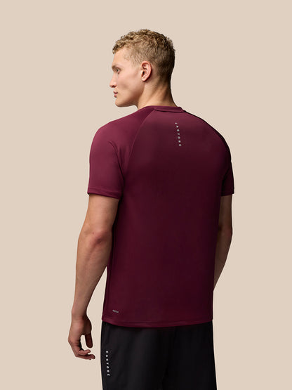 Back view of burgundy Adapt Training T-Shirt on model with vertical Castore branding along the upper back