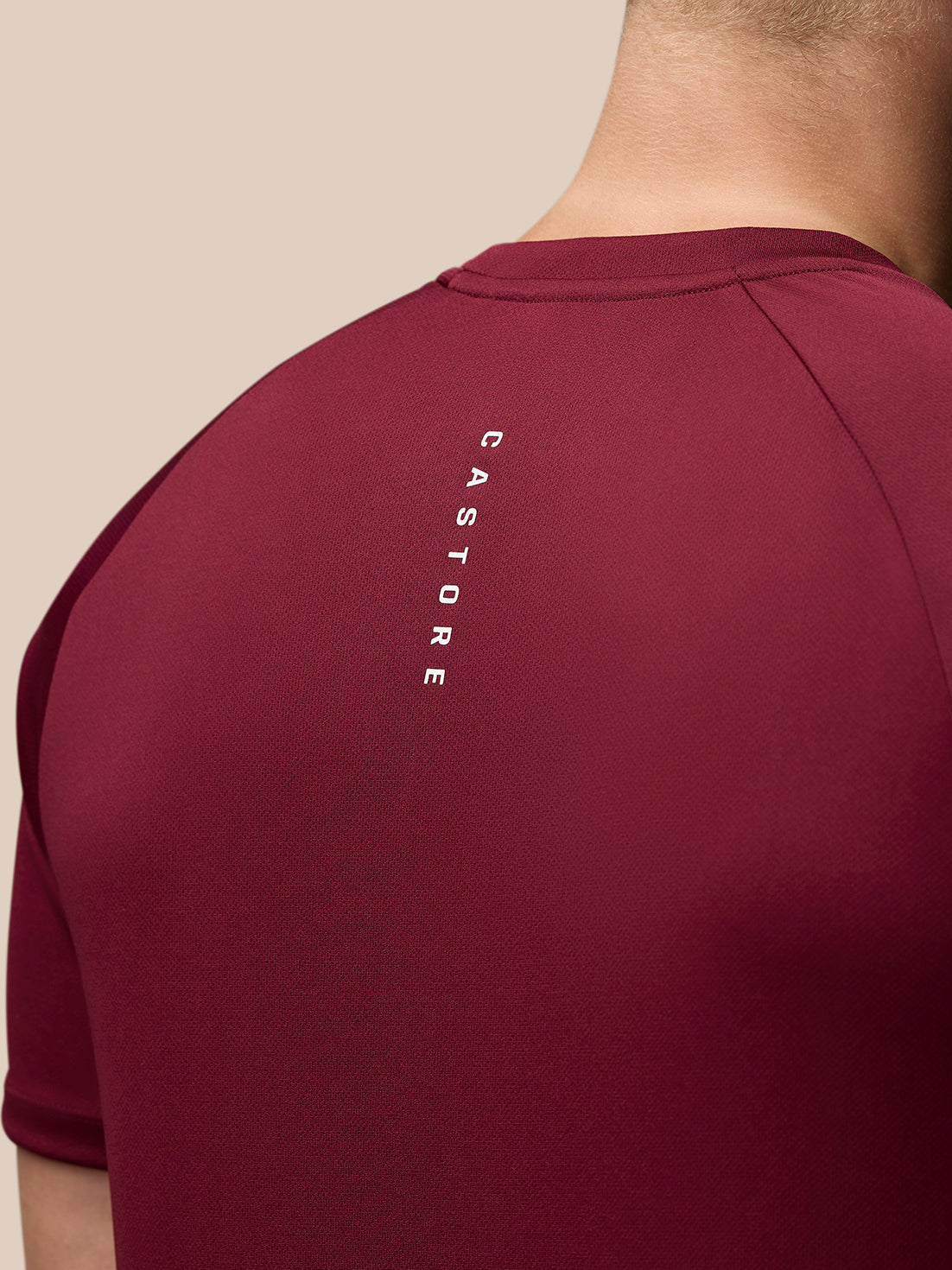 Back view of burgundy Adapt Training T-Shirt with vertical CASTORE branding along the upper back