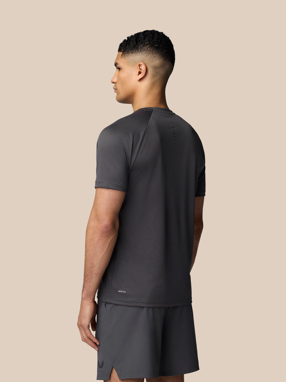 Back view of a man in gunmetal Adapt Short Sleeve T-Shirt with Castore branding along the upper back